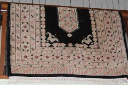 Eastern design rug with a black ground, 1.80 by 1.25.