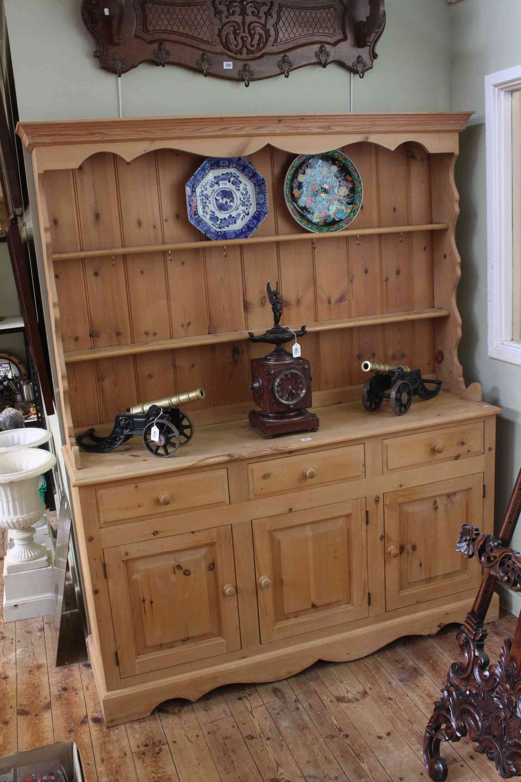 Pine dresser having shelf back above three drawers with three doors below, 191cm by 152cm.