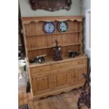 Pine dresser having shelf back above three drawers with three doors below, 191cm by 152cm.