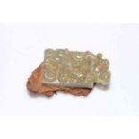 Small Chinese jade carving of dragons attached to rustic metal.