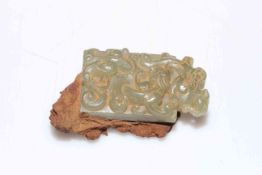 Small Chinese jade carving of dragons attached to rustic metal.