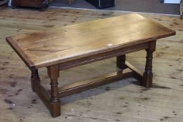 Rectangular oak coffee table on turned legs joined by block stretcher, 48cm by 119.5cm.