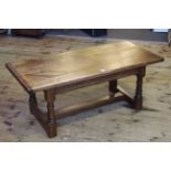 Rectangular oak coffee table on turned legs joined by block stretcher, 48cm by 119.5cm.