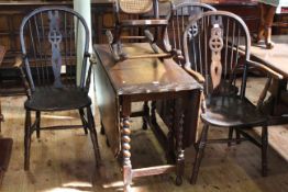 Oak barley twist gateleg dining table with carved border and three wheelback elbow chairs.
