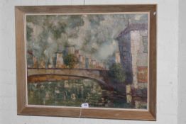 Gilt framed oil on canvas of a bridge over a river with a town in the background, 59cm x 79cm.