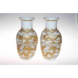 Pair Chinese vases having applied gilt decoration of pagoda and dragons on white ground, 30cm.