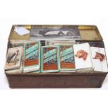 Tin of cigarette cards including Wills, Players, Ogdens, Churchman, Godfrey Phillips.