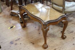 Walnut coffee table of serpentine form on ball and claw legs, 84cm by 47cm.