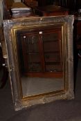 Rectangular swept gilt frame bevelled wall mirror, 118cm by 88cm overall.