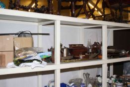 Full shelf of metalware, stoneware bottles, camera equipment, desk stands, cigarette cards, linen,