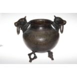 Islamic engraved bronze pot raised on three ring style feet with bull and ring handles.