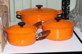Le Creuset cookware including two pans and casserole dish.