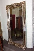 Rectangular ornate framed bevelled wall mirror, 203cm by 102cm overall.