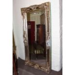 Rectangular ornate framed bevelled wall mirror, 203cm by 102cm overall.