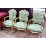 Set of three gilt painted fauteuils in green buttoned fabric.