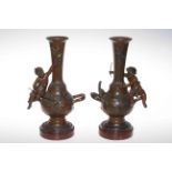 Pair Victorian brown and gilt painted bronze vases, each having joyful putti seated on handle,
