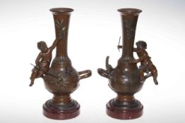 Pair Victorian brown and gilt painted bronze vases, each having joyful putti seated on handle,