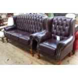 Burgundy buttoned leather and brass studded three seater wing back settee and chair.