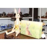 Jointed wooden rabbit and small footstool upholstered with rabbit pattern fabric.