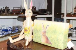 Jointed wooden rabbit and small footstool upholstered with rabbit pattern fabric.