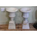 Pair small cast campana style garden urns on stands, 51cm by 28cm diameter.