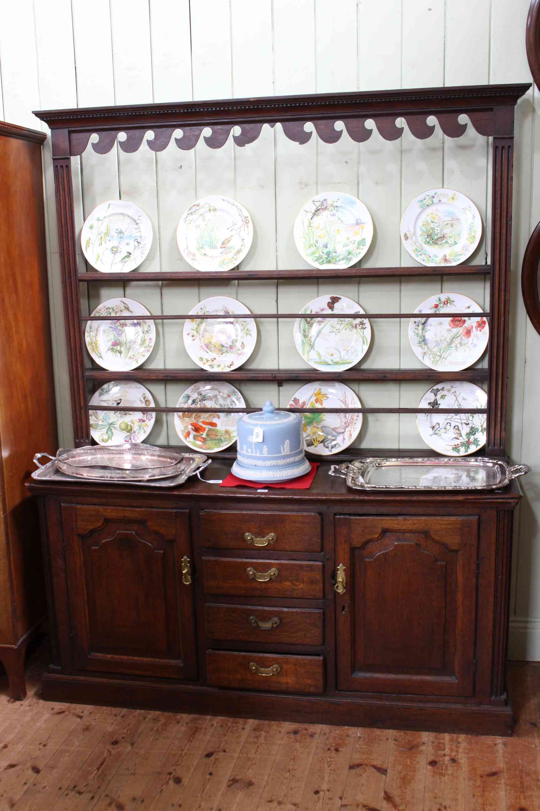 Georgian oak dresser and Delft rack having three central drawers flanked by two arched fielded