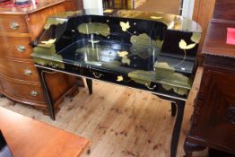 Black lacquered and floral decorated writing desk, 99cm by 130cm,