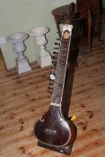 Antique Bombay sitar on stand.