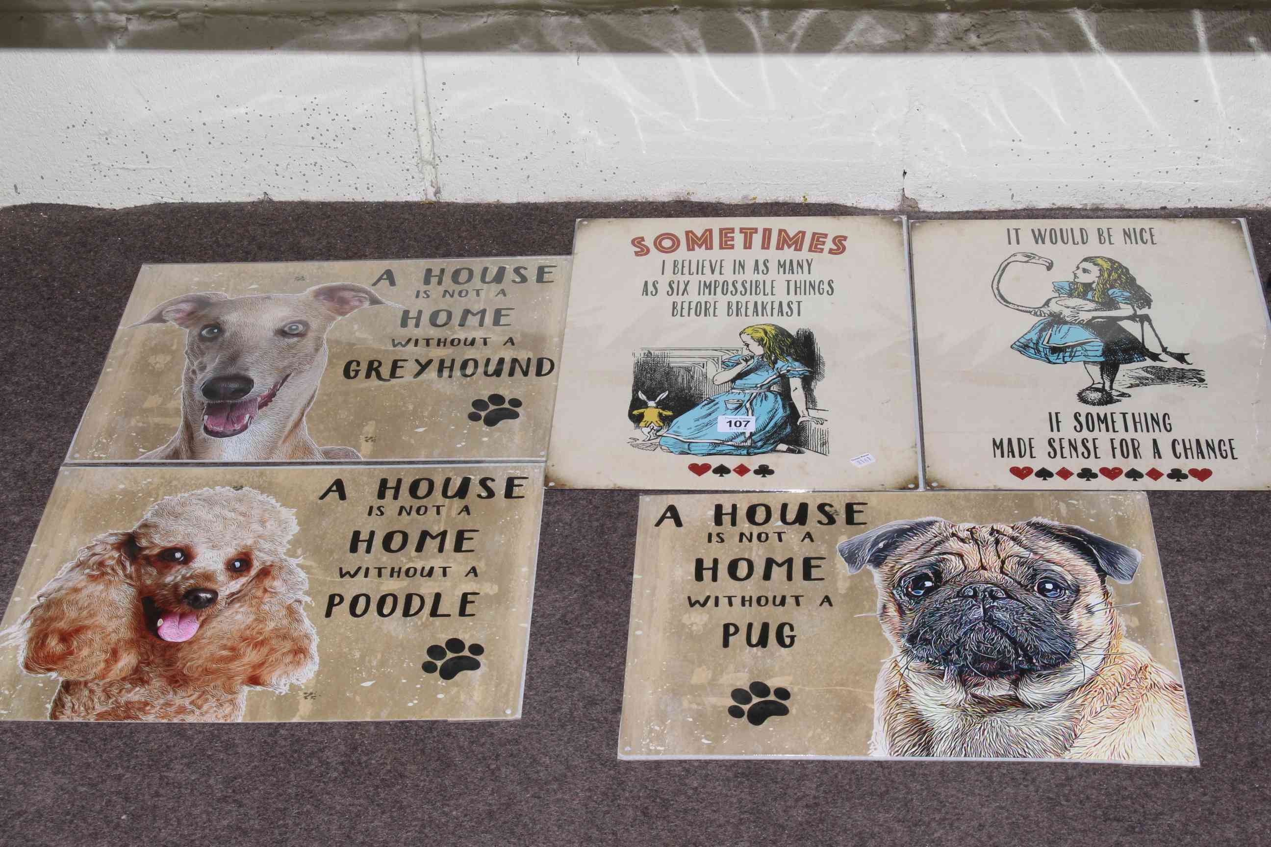 Five signs: Three 'A House is not a Home' dogs and two 'Alice in Wonderland'.