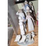 Eleven figurines including Lladro, Nao and Spode.