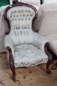 Victorian carved mahogany armchair in buttoned fabric.
