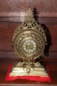 Ornate brass mantel clock with enamel style numbers, 46cm high.