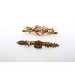 Two 9 carat gold coloured brooches with red stones.