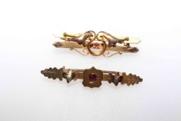 Two 9 carat gold coloured brooches with red stones.