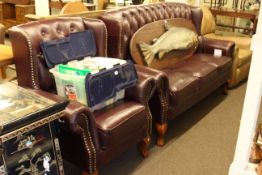 Burgundy buttoned and brass studded three seater wing back settee and chair.