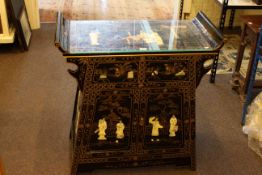 Oriental style black lacquered and painted two door altar table/cabinet with applied figure