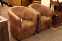 Pair distressed suede tub chairs.