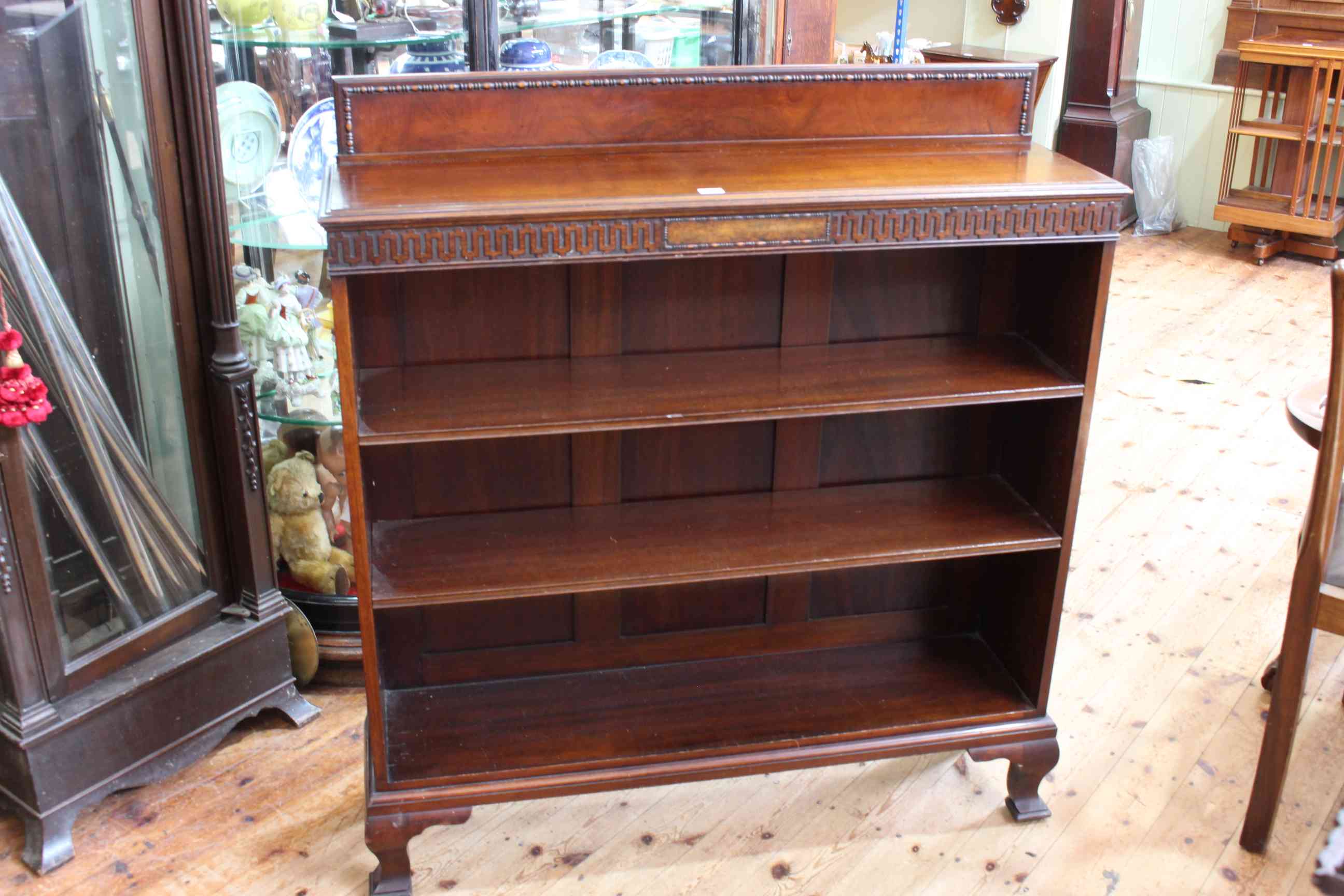 1920's mahogany open bookcase on cabriole legs having two adjustable shelves, 119cm by 108cm.