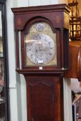 Antique oak eight day longcase clock having arched brass and silvered dial.