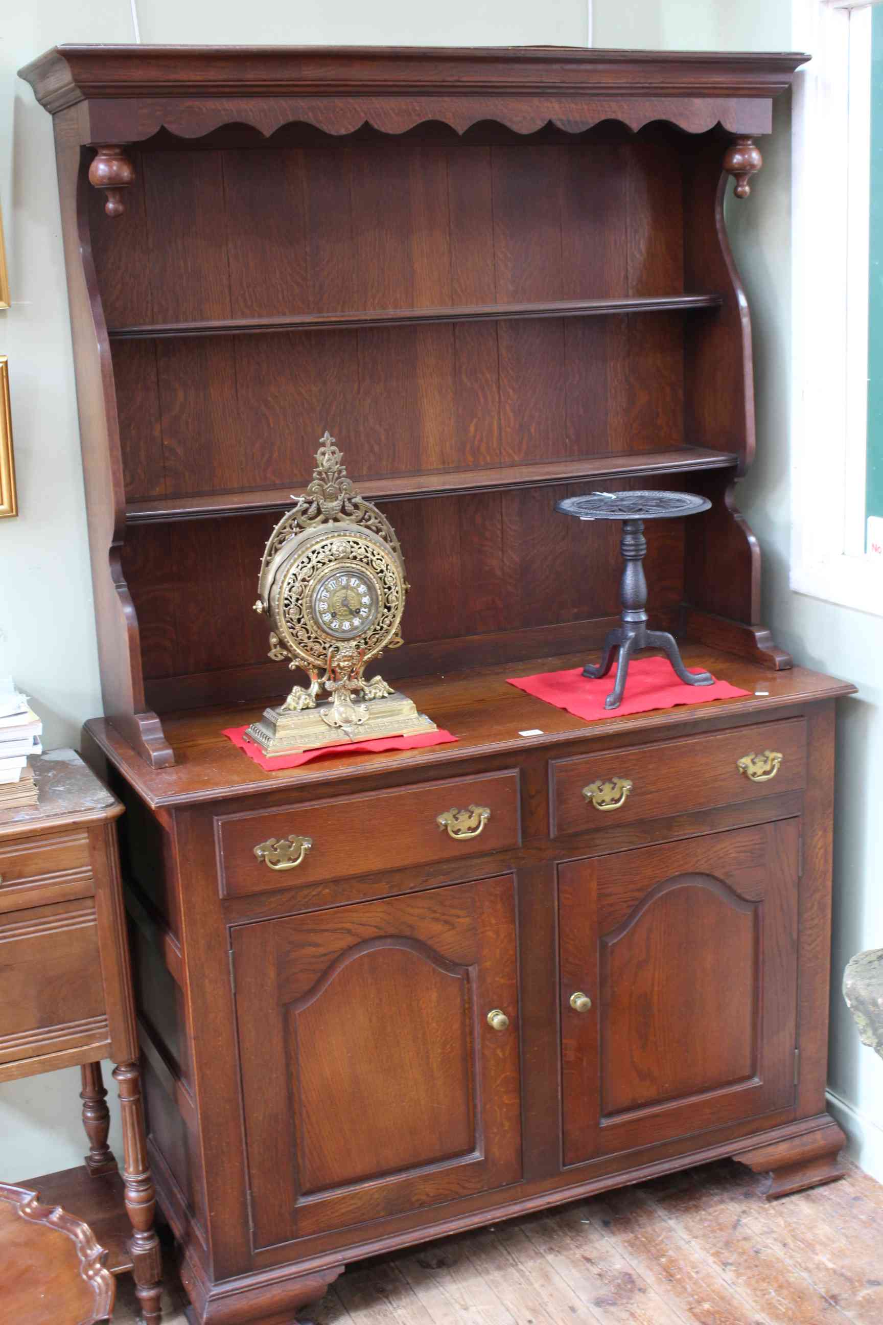 Oak shelf back dresser having two drawers above two arched fielded panel doors on ogee bracket feet,