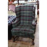 Georgian style wing armchair on ball and claw feet in tartan fabric.