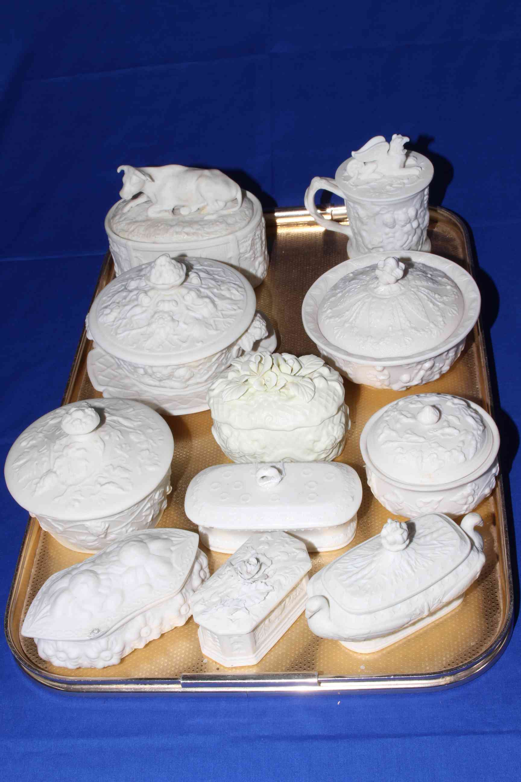 Collection of eleven Victorian Parian relief moulded boxes, including Bacchus, Cow, Cherubs, etc.