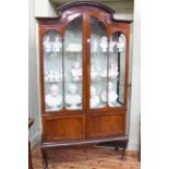 Edwardian mahogany arched top vitrine having two glazed panel doors above two cupboard doors on