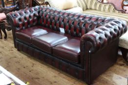Ox blood deep buttoned leather three seater Chesterfield settee, 193cm by 85cm.