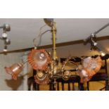 Ornate brass five branch chandelier with etched amber tinted shades.