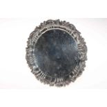 George IV silver salver, engraved with foliage and having ornate border, on paw feet,