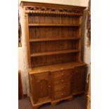 Pine dresser, the shelf back above a breakfront base of four drawers and two carved panel doors,