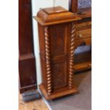 Late 19th/early 20th Century slim oak cabinet having two carved panel doors with twist pillars,