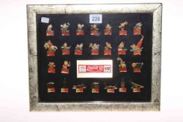 Framed collection of 25 Coca Cola badges for 1992 Spanish Olympics.