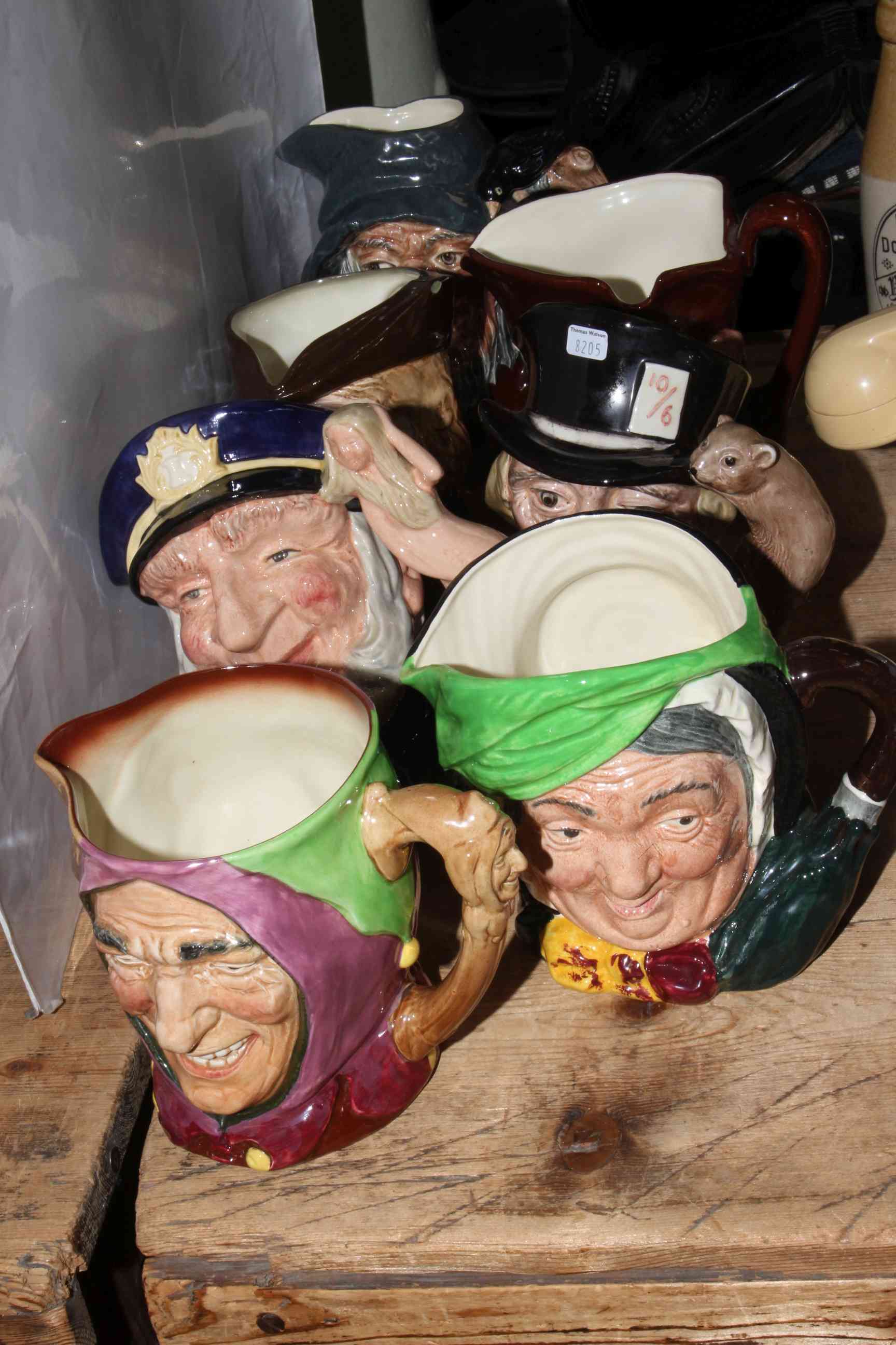 Collection of seven Royal Doulton character jugs including Touchstone and Robin Hood.